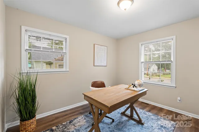a view of a workspace with furniture and a window