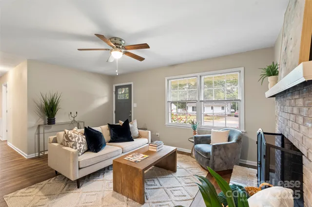 a living room with fireplace furniture and a large window