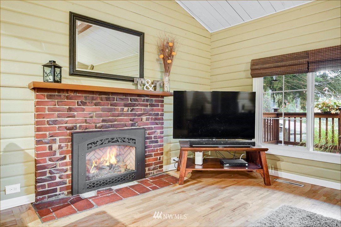 527 240th Street Southwest Bothell, WA 98021 - Photo 4 of 32 a living room with a fireplace and a flat screen tv