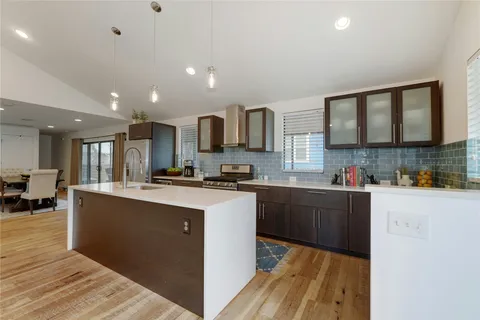a kitchen with stainless steel appliances granite countertop a stove sink and cabinets