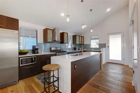 a kitchen with stainless steel appliances granite countertop a refrigerator and a stove top oven