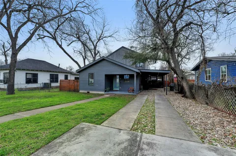 a front view of a house with a yard and trees