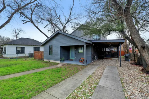 a front view of a house with a yard and trees