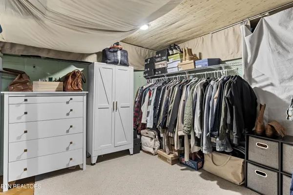 a view of a big house with a big yard couches and wooden fence