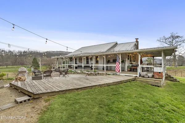 a view of a house with swimming pool and porch with furniture