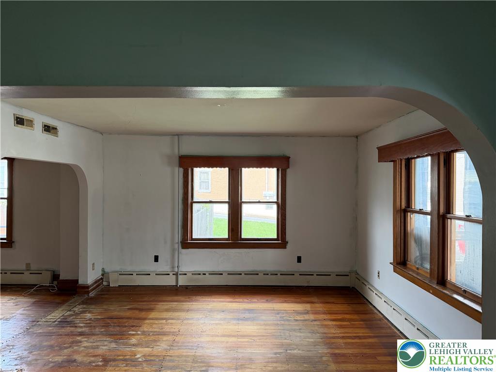 144 South Front Street Coplay, PA 18037 - Photo 5 of 24 Wooden window trim and original hardwood flooring frame this blank-canvas living space.