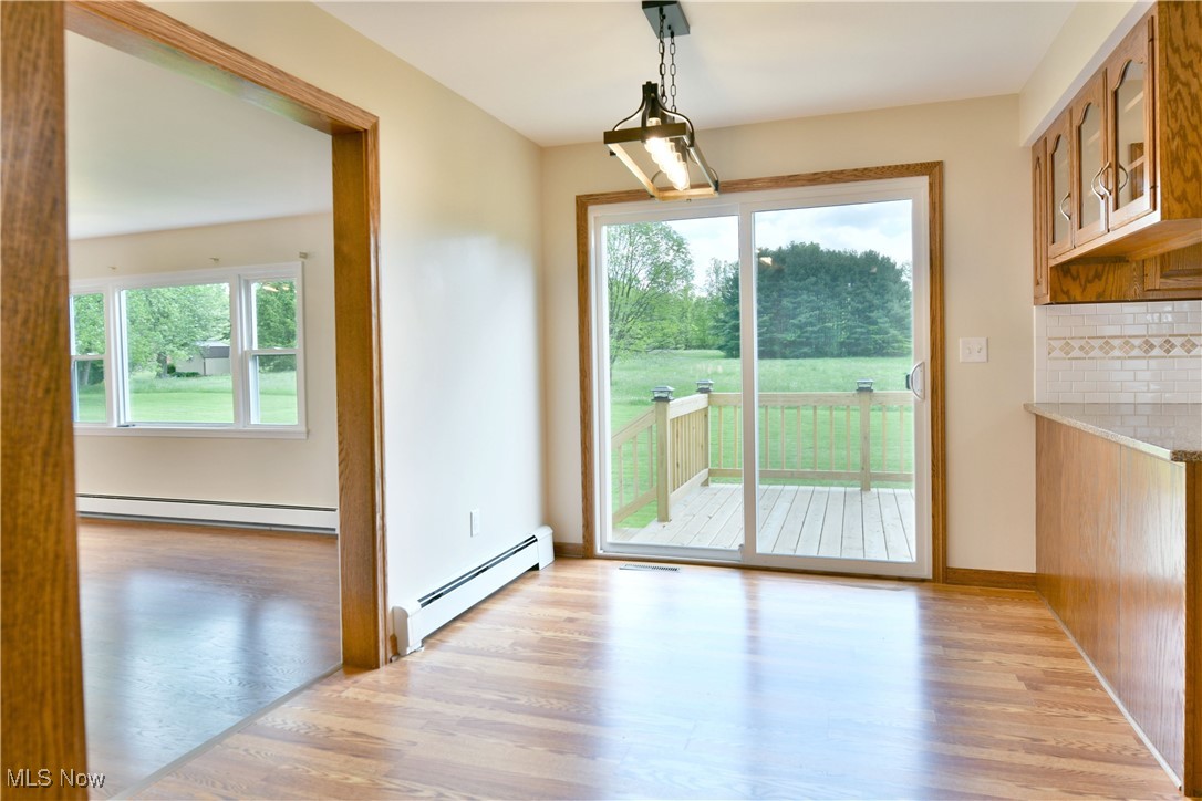 2153 Stillwagon Road Southeast Warren, OH 44484 - Photo 19 of 50 Unfurnished dining area with a baseboard radiator and light wood-type flooring