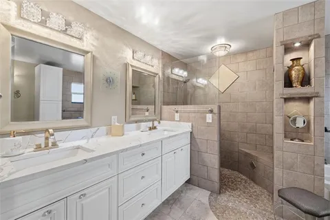 a bathroom with a double vanity sink mirror and shower