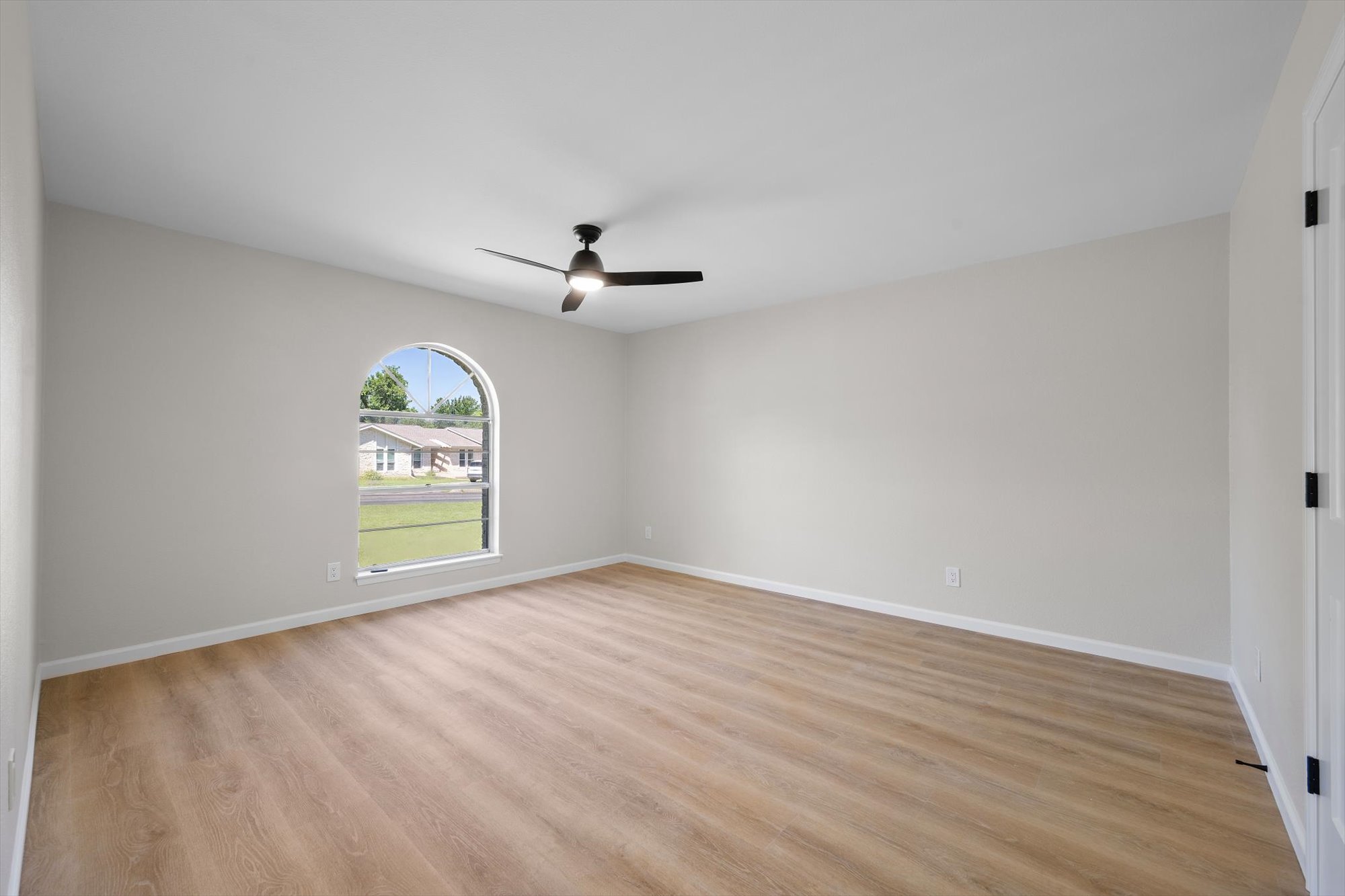 109 Woodland Road Georgetown, TX 78628 - Photo 32 of 40 An arched window and warm-toned wood flooring adorn this tranquil room.