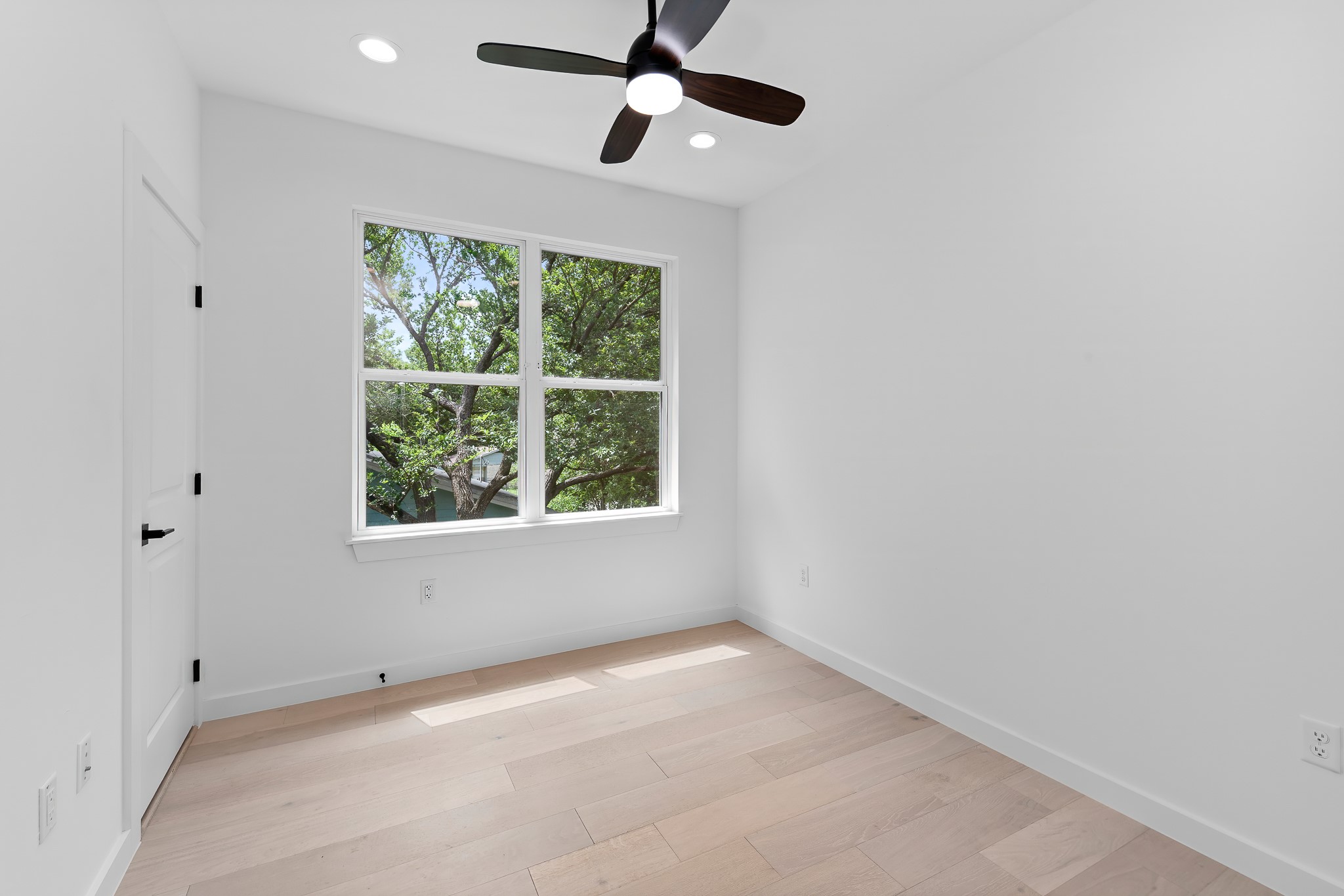 5305 Ledesma Road, Unit 4 Austin, TX 78721 - Photo 24 of 40 A well-lit bedroom features hardwood flooring and a refreshing ceiling fan for comfort.
