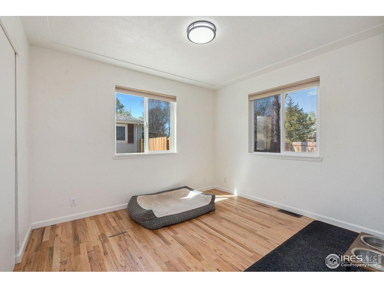 113 Balsam Street Fort Morgan, CO 80701 - Photo 16 of 30 a view of an empty room with window and wooden floor