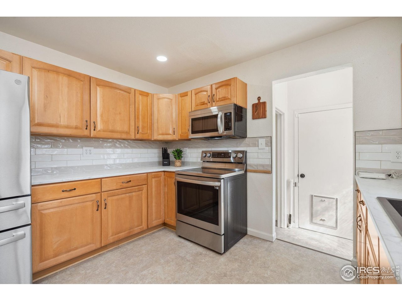 113 Balsam Street Fort Morgan, CO 80701 - Photo 6 of 30 a kitchen with stainless steel appliances granite countertop a stove a sink and a microwave