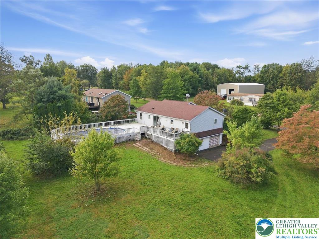 74 Swiss View Road Lehighton, PA 18235 - Photo 56 of 59 Lush green lawns and mature trees surround this suburban property featuring an elevated wooden deck.