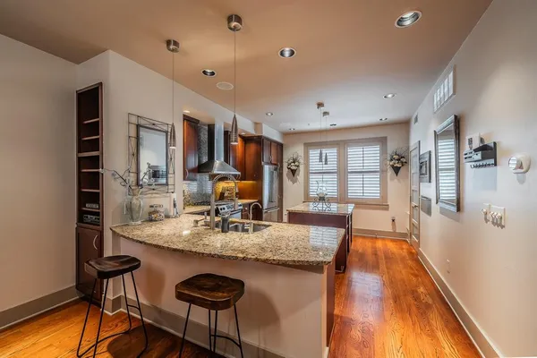 a kitchen with stainless steel appliances granite countertop a refrigerator a stove and a sink