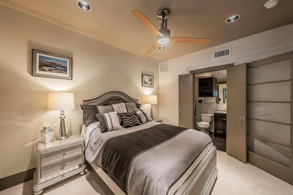 a bedroom with a large bed and a chandelier