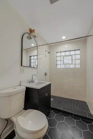 a bathroom with a toilet a sink and mirror