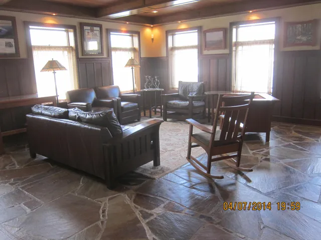 a living room with furniture a large window and wooden floor
