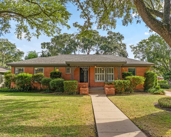 a front view of a house with a yard and potted plants
