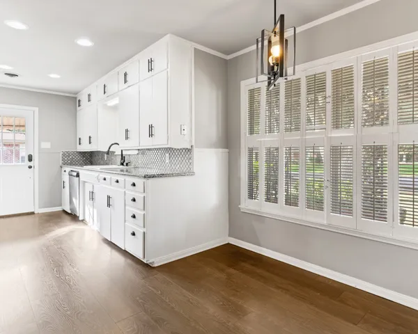 a kitchen with stainless steel appliances sink cabinets and wooden floor
