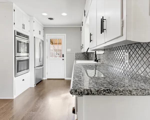 a kitchen with stainless steel appliances granite countertop a sink and a refrigerator