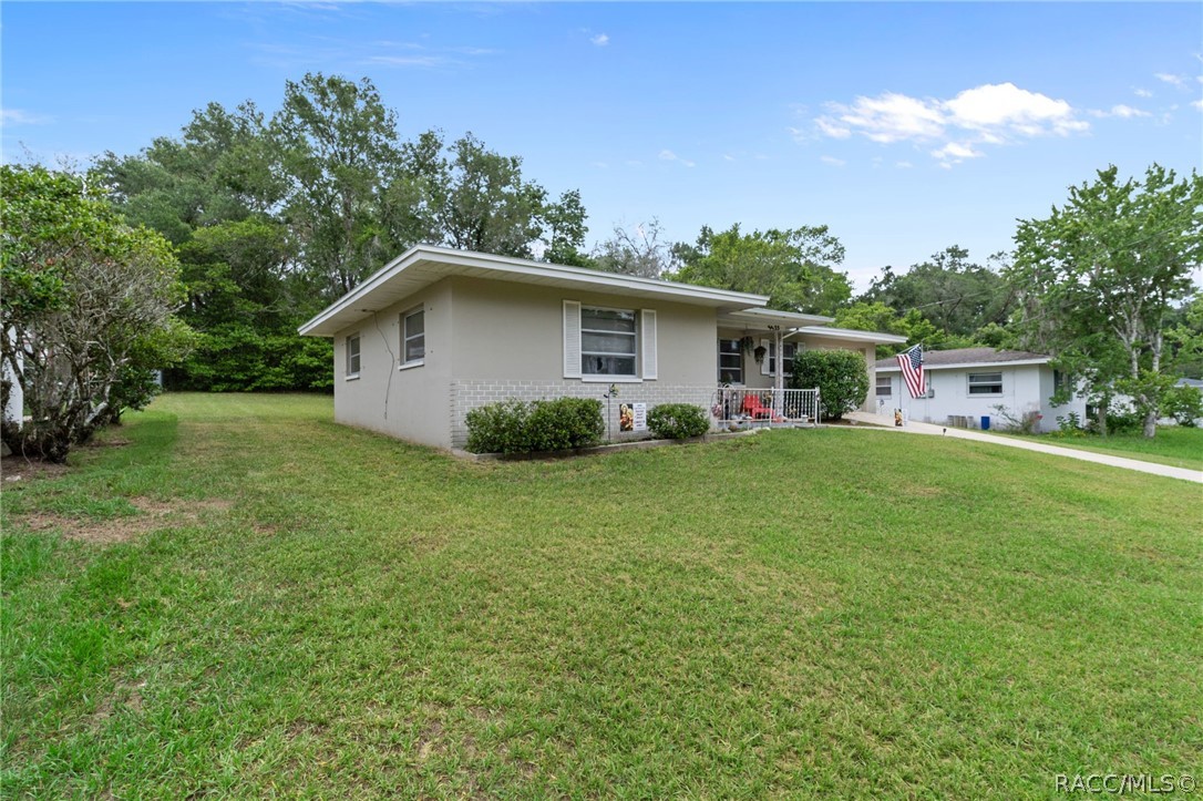 3355 South Highlands Avenue Inverness, FL 34452 - Photo 1 of 30 a white house that has a small yard and a trees in it