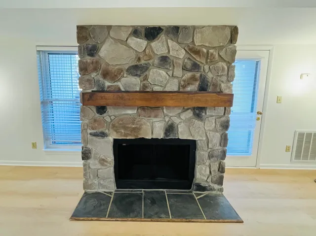 a living room with a fireplace and a rug