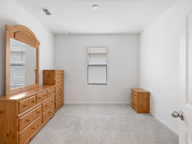 a bedroom with a bed and a mirror on dresser