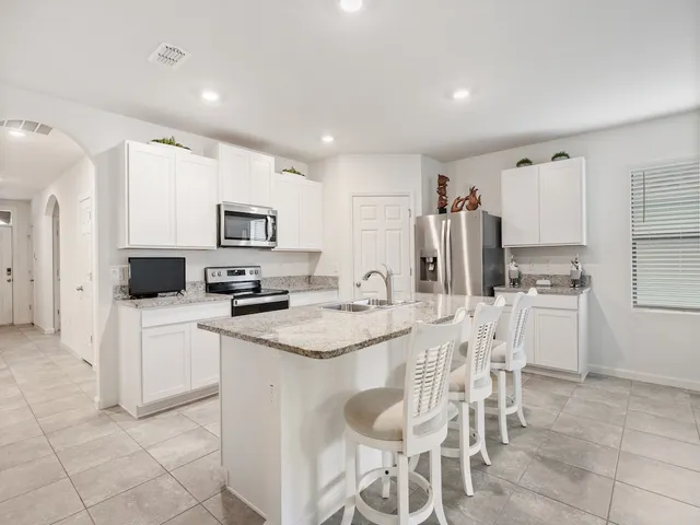 a kitchen with white cabinets and stainless steel appliances