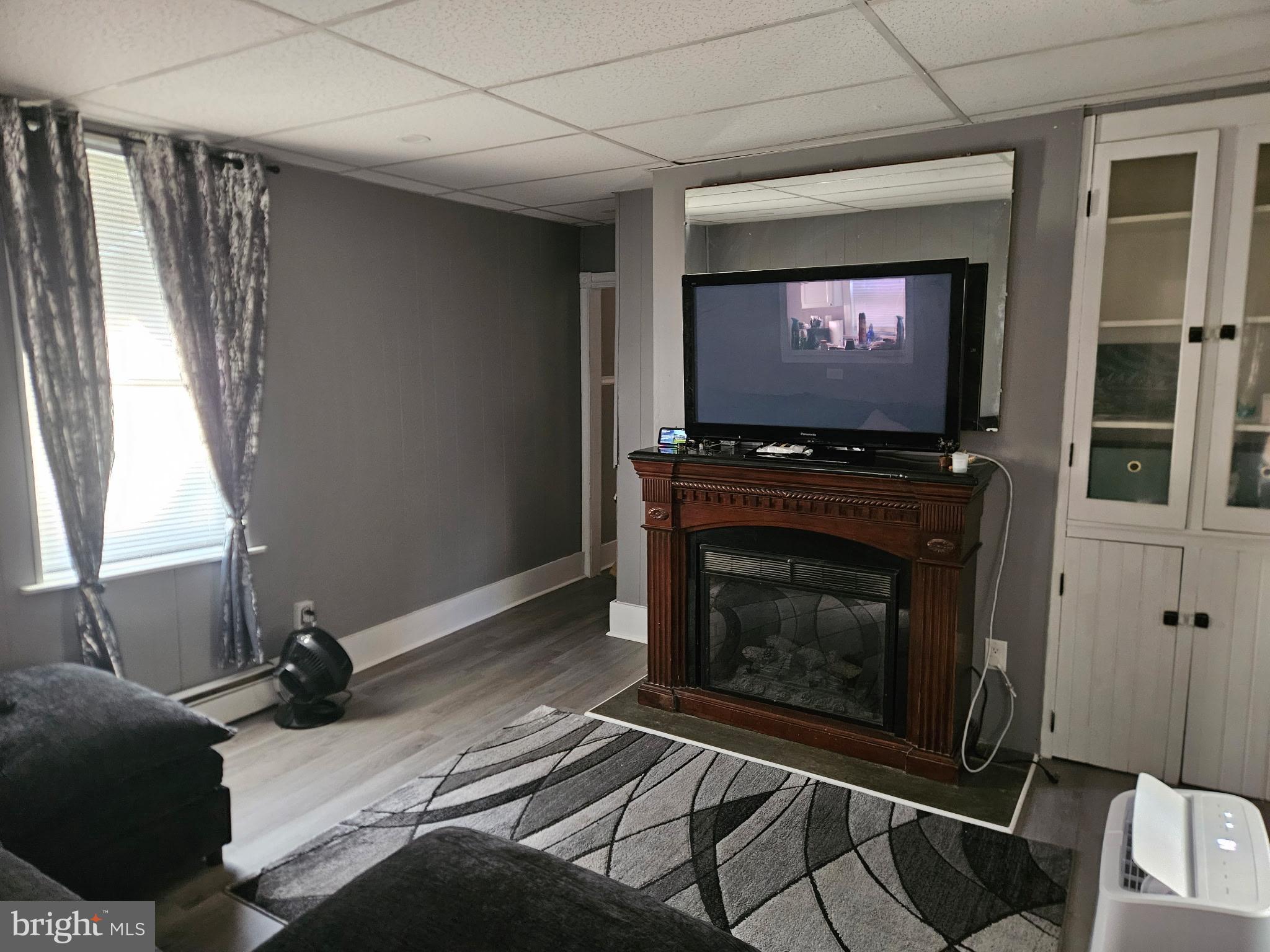 11 Washington Street Mount Holly, NJ 08060 - Photo 7 of 19 a living room with a fireplace furniture a flat screen tv and a window