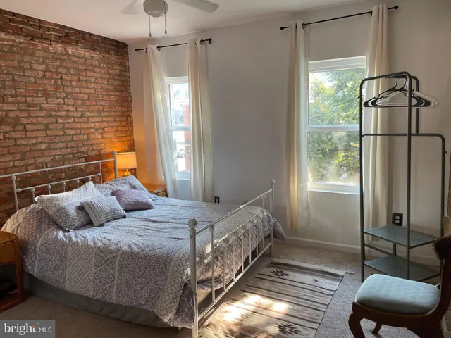 a bed sitting in a bedroom next to a window