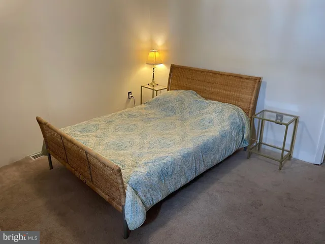 a bed sitting in a bedroom next to a lamp