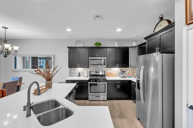 a kitchen with stainless steel appliances granite countertop a sink stove and refrigerator