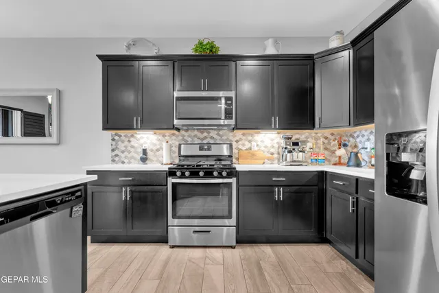 a kitchen with stainless steel appliances granite countertop a refrigerator and a stove