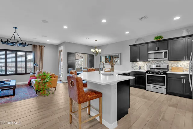 a kitchen with stainless steel appliances granite countertop a refrigerator and a sink