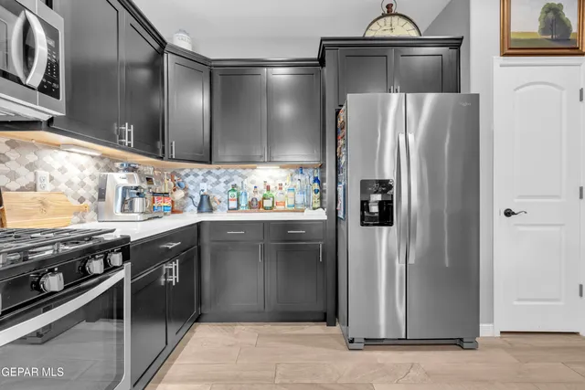 a living room with stainless steel appliances kitchen island granite countertop furniture a rug kitchen view and a chandelier