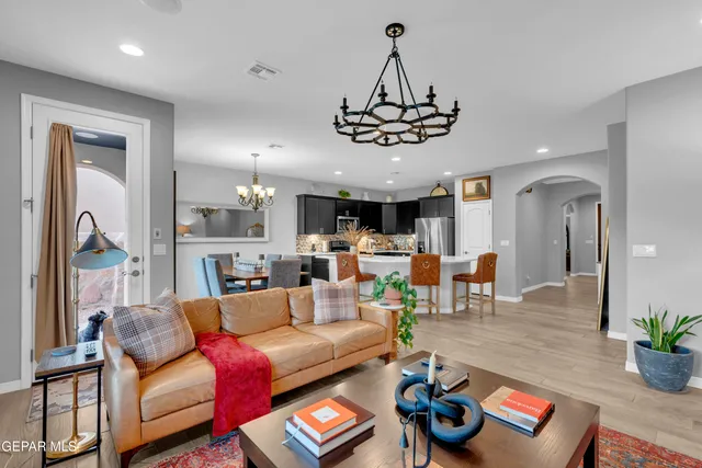 a spacious bedroom with a bed and chandelier