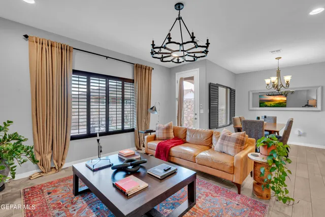 a bedroom with bed tv and chandelier