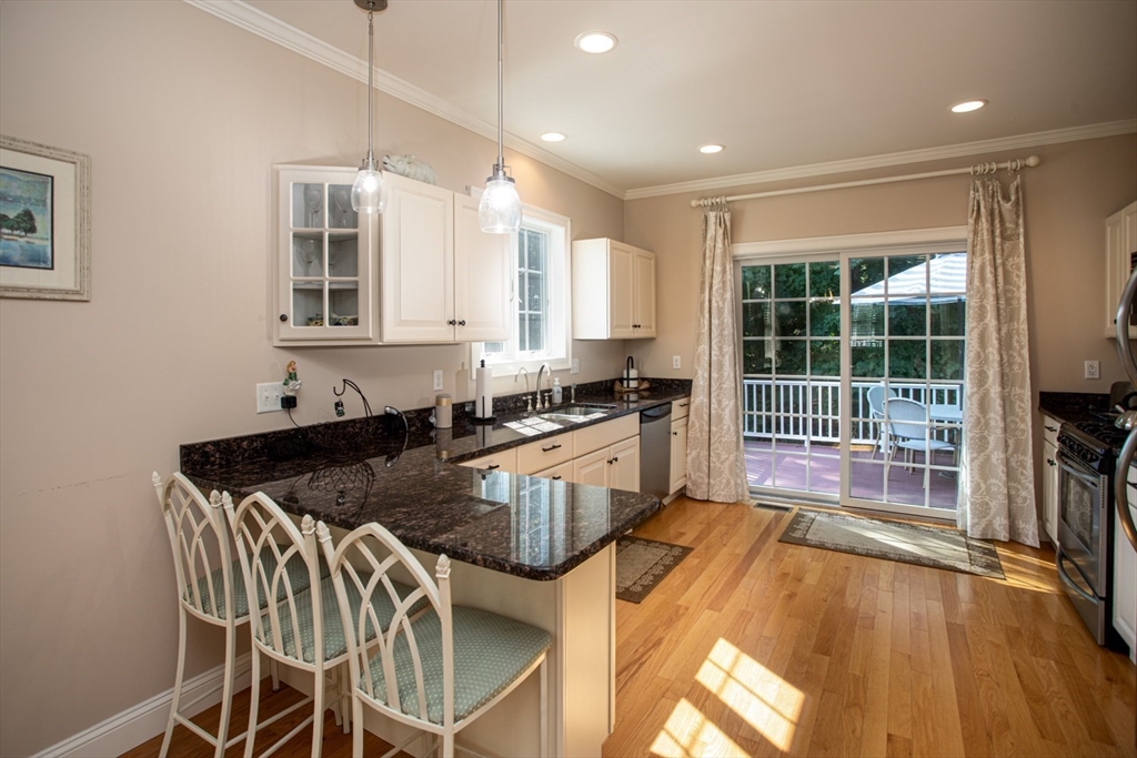 1346 Main Road, Unit B Westport, MA 02790 - Photo 12 of 29 a kitchen with granite countertop a stove a sink a dining table and chairs