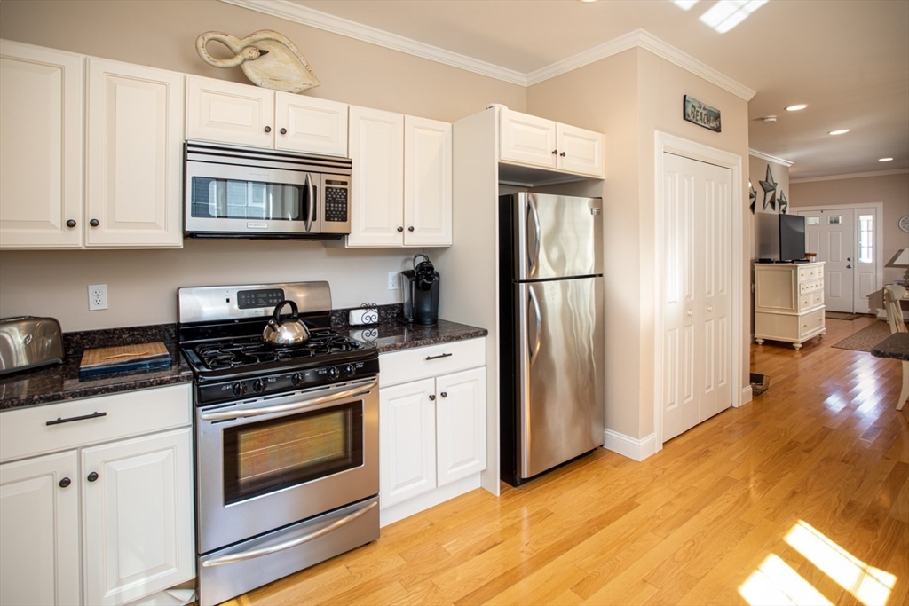 1346 Main Road, Unit B Westport, MA 02790 - Photo 14 of 29 a kitchen with stainless steel appliances white cabinets and a stove