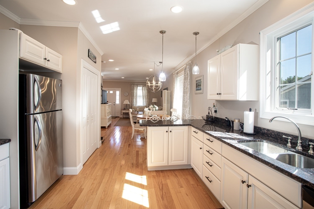 1346 Main Road, Unit B Westport, MA 02790 - Photo 15 of 29 a kitchen with stainless steel appliances granite countertop a refrigerator a sink dishwasher a stove and white cabinets with wooden floor