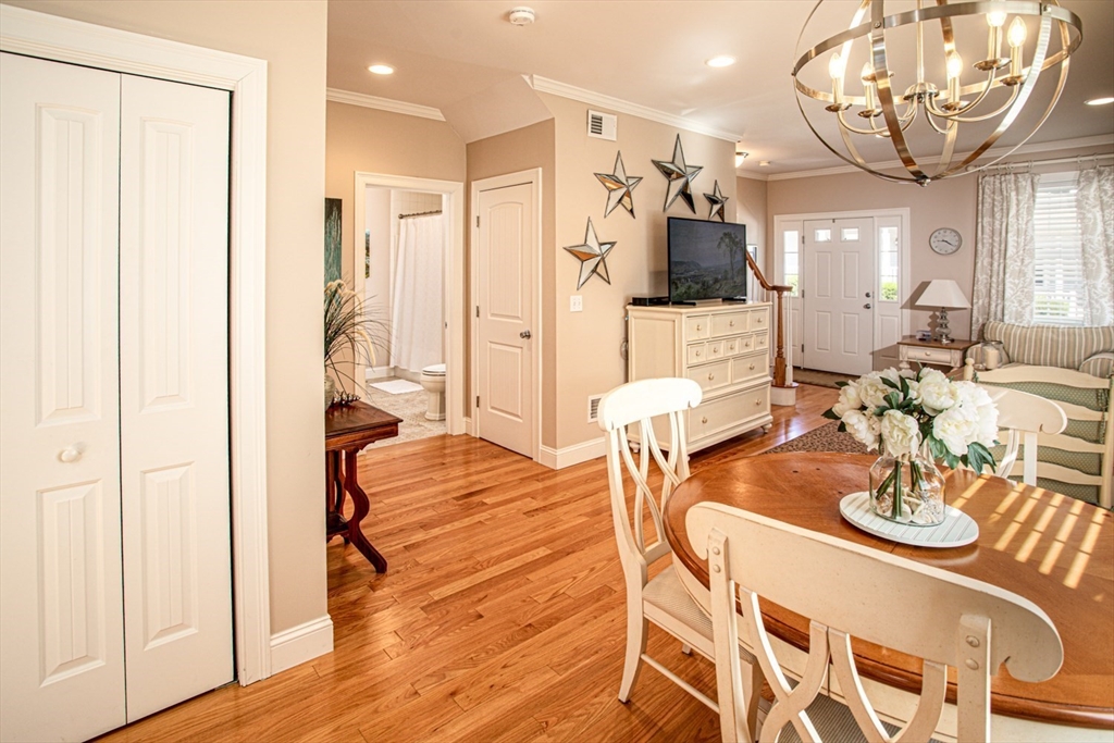 1346 Main Road, Unit B Westport, MA 02790 - Photo 10 of 29 a view of a dining room with furniture a chandelier and wooden floor
