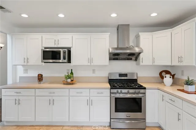 a kitchen with a sink a counter top space appliances and cabinets