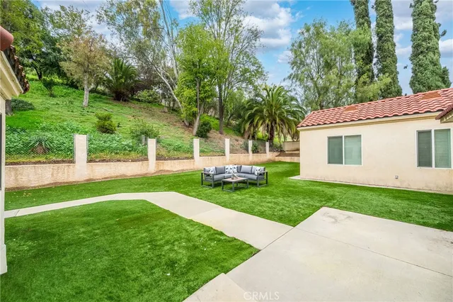 a view of a chair and table in backyard of the house
