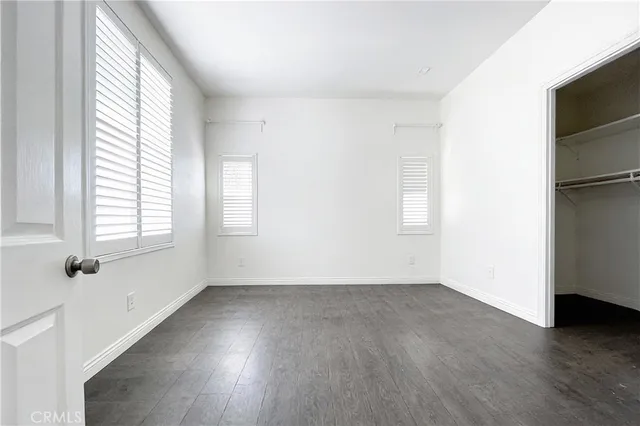 a view of a white house with a big yard plants and large trees
