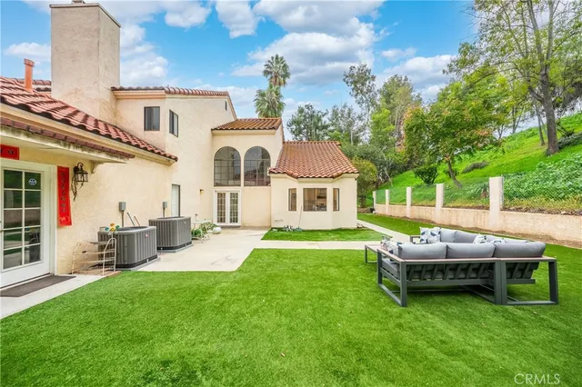 a view of a white house with a yard and large tree
