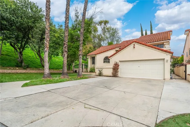 a view of a house with a yard and large tree