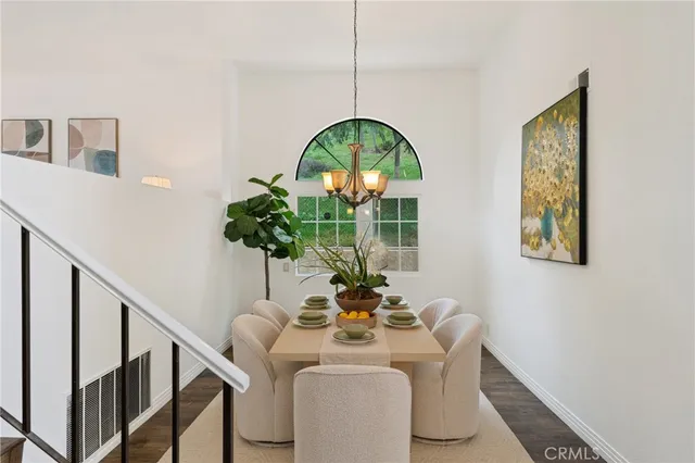 a dining room with furniture potted plants and wooden floor
