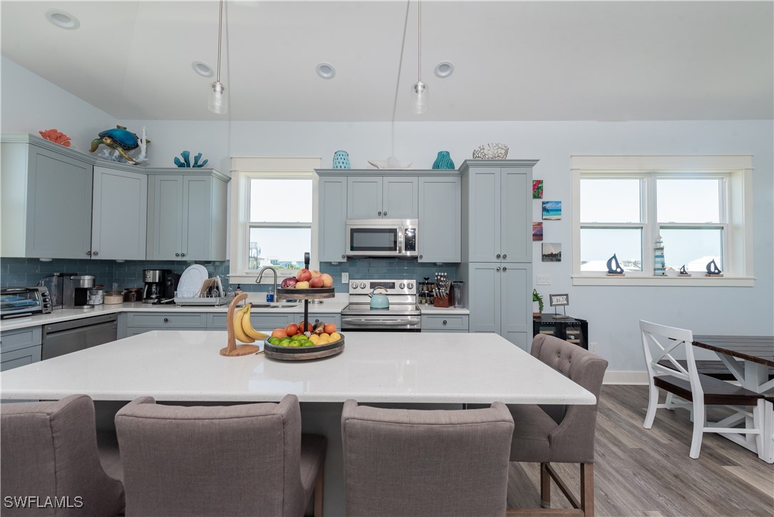 4500 Butterfly Shell Drive Captiva, FL 33924 - Photo 9 of 42 a kitchen with a sink a stove and white cabinets
