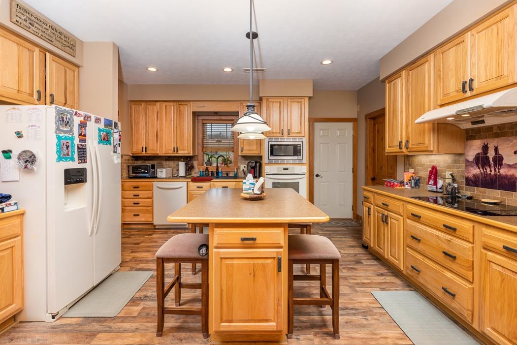 2564 Mt Torrey Road Lyndhurst, VA 22952 - Photo 24 of 64 a kitchen with stainless steel appliances kitchen island granite countertop a refrigerator a stove and white cabinets with wooden floor