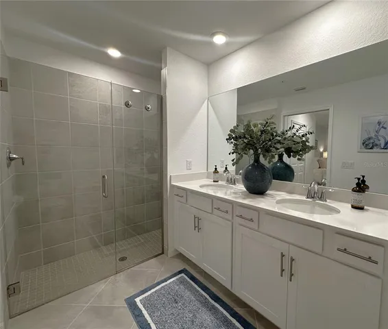 a bathroom with a shower sink and mirror